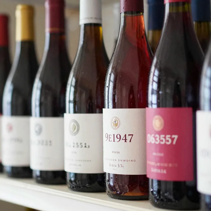 A shelf of hand-labeled low-intervention wine bottles